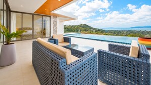 Ein moderner Außenbereich mit Sitzgelegenheiten, einem Pool und Blick auf eine Berglandschaft.