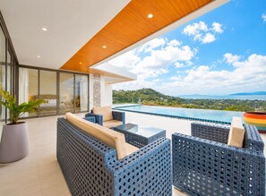 Un espace extérieur moderne, aménagé avec des sièges, une piscine et offrant une vue sur un paysage montagneux.