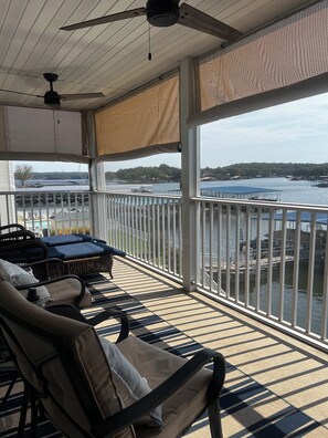 A covered outdoor area with a view of a body of water, featuring a seating area with chairs and a table. - 3-bedroom, 2-bath condo in amazing Sunrise Beach.  
This Condo sleeps 10 guests (Sunrise Beach)