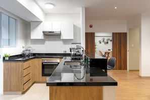 A modern kitchen with a central island, built-in oven, and stainless steel appliances. - 90m² apartment with parking, just steps from Kennedy Park. (Miraflores)