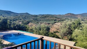 A swimming pool with a wooden deck and a view of a mountainous landscape. - Isolated luxury villa with pool, 30 mins to sea, 2 km to village shops tavernas (messenia)
