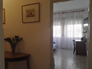 A room with a dining table, chairs, a bed, and a window with sheer curtains. - Apartment 'The Serendipity' (Lido di Ostia)