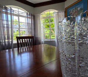 A room with a wooden table, two windows with curtains, and a framed picture on the wall. - Sukasa Ville 3 beautiful bedroom
Perfect for family
The villa edition (Trelawny)