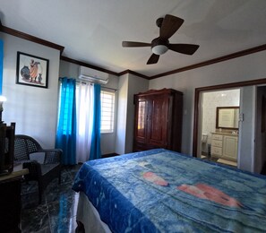 A bedroom with a bed, a ceiling fan, a wardrobe, a chair, and a window with curtains. - Sukasa Ville 3 beautiful bedroom
Perfect for family
The villa edition (Trelawny)