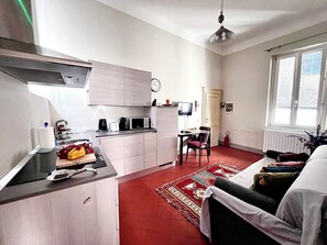 A compact living space with a kitchenette, a dining area, and a seating area with a red carpet. - Liù, Central and cozy apartment in Lucca (LUCCA)