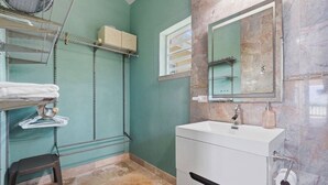 A bathroom with a white sink, a mirror, a towel rack, and a shower area. - Luxury 2 bedroom Waterfront Villa Private Pool, & Spacious Deck (Frederiksted)