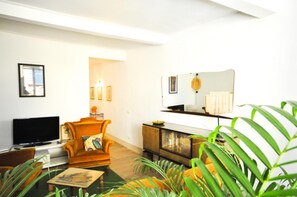A living room with a television, a sofa, a coffee table, and a cabinet. - Casa del Papavero city center (LUCCA)