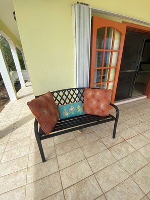 A bench with patterned cushions, a tiled floor, and a door with a glass panel. - Lovely 2BR Villa Plus a New Pool-Stunning Views of St. Maarten (George Hill)