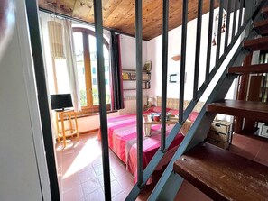 A room with a bed, a desk, and a staircase. - Casa Silvia a piedi dalle mura AC (LUCCA)