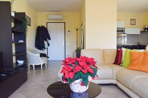 A living room with a sofa, a coffee table, and a potted plant. - Casa ai giardini in front of the ancient wall (LUCCA)