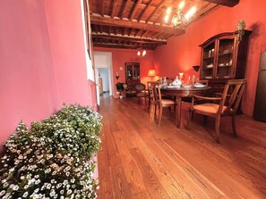 A dining area with wooden furniture, a chandelier, and a cabinet. - Casa Florian in the historic center (LUCCA)