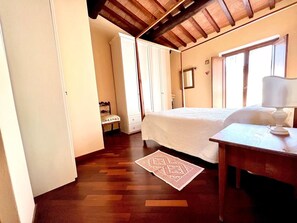 A bedroom with a bed, bedside table, and a chair. - Casa Pozzi in the heart of the Lucca hills (Capannori)