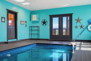 A swimming pool with a tiled edge, a door, and a window with a view. - New Listing, Hot Tub, Private Indoor Heated Pool, Game Room, Theater Room (Pigeon Forge)