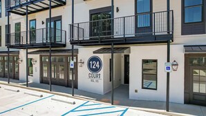Un edificio residencial de varios pisos con balcones, un cartel que indica '124 Court BSL MS' y un letrero de estacionamiento reservado.