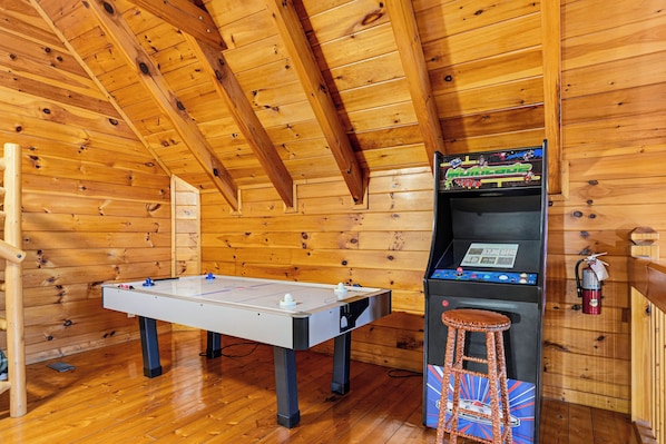 A wooden room with a foosball table and a video game machine. - New Listing, Hot Tub, Game Room, Free Attractions (Sevierville)