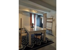 A compact living space with a dining table, a bunk bed, and a patterned rug. - Charming, modern apartment in the heart of the city (Béziers)