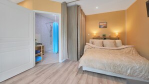 Une chambre à coucher avec un lit, une douche et une porte donnant sur une autre pièce.
