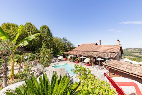 A pool area with lounge chairs, a covered seating area, and a view of the surrounding landscape. - L’Échappée Belle - joli appt avec piscine partagée (Caylus)