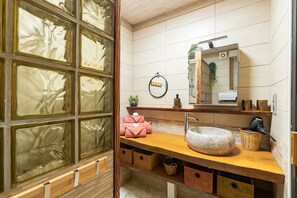 A bathroom with a wooden vanity, a stone sink, and a mirror. - L’Échappée Belle - joli appt avec piscine partagée (Caylus)