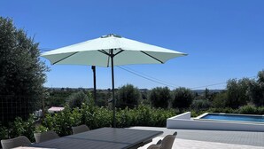 An outdoor patio with a table and chairs, a pool, and a clear blue sky. - Scallabis House, the perfect starting point for exploring the Gothic Capital. (Várzea)