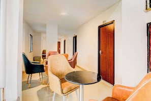 A hotel corridor with a dining area featuring a round table and multiple chairs. - Townhouse Nampally Metro Station Hyd (Hyderabad)