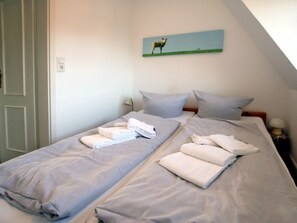 A twin room with two beds, each with a pillow and a folded towel. - 8, Dorpstraat 9 (Wyk auf Foehr)