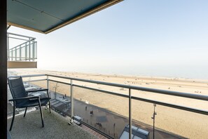 Ein Balkon mit Blick auf einen Strand und das Meer.