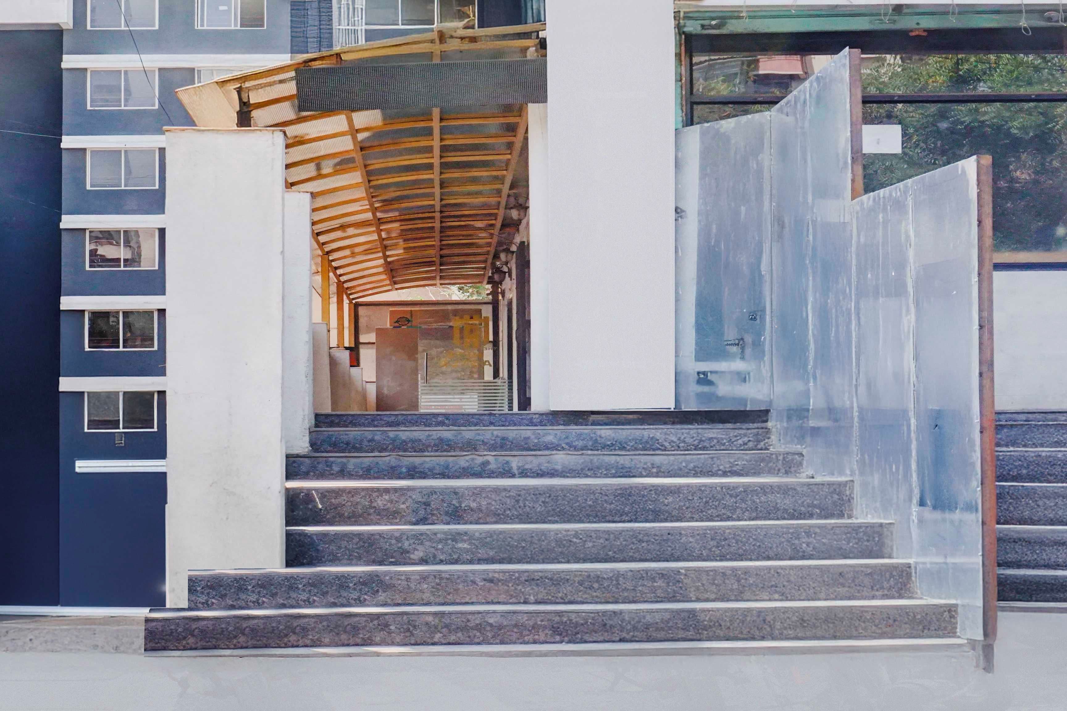 A staircase leading to an entrance with a wooden canopy and a metal gate.