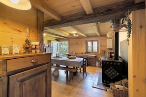 Un'accogliente interno in legno con zona pranzo, mobili in legno e un tradizionale stufa.