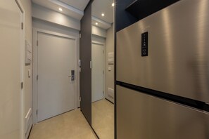 Eine moderne Küche mit einem Edelstahl-Kühlschrank, einem Einbauofen und einer Mikrowelle.