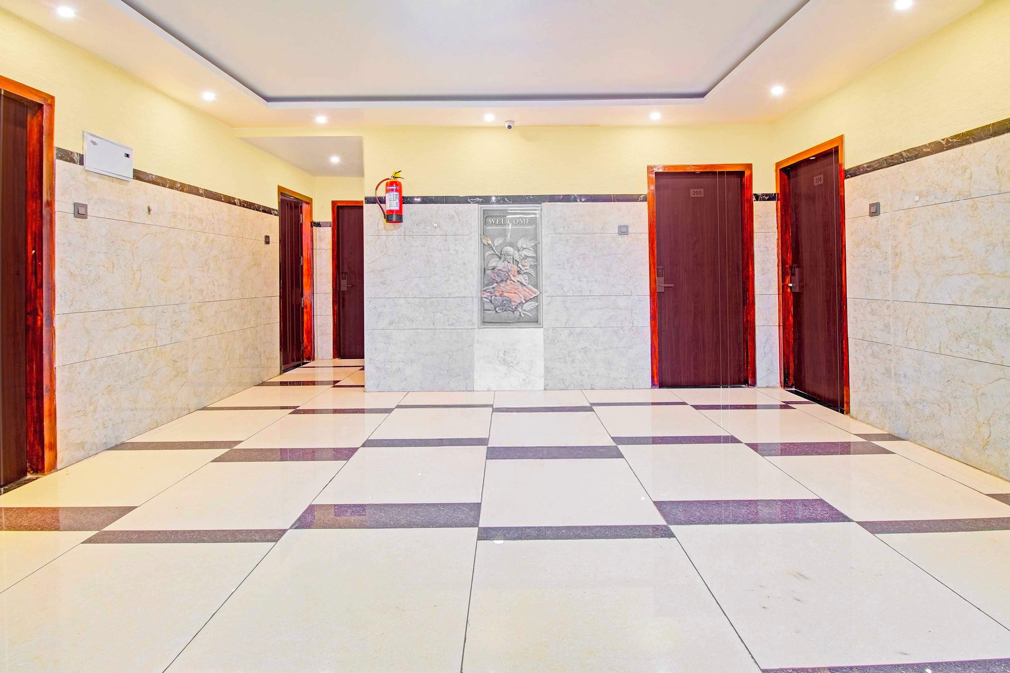 A hotel lobby with a checkered floor, marble walls, and wooden doors numbered 205 and 206.