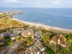 A coastal residential area with houses, a beach, and a pier. - Holiday Home With 1 Bedroom (Sylt)