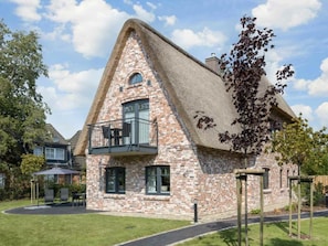 A brick house with a steeply pitched roof and a balcony. - "vorn Binnendiek" (St. Peter-Ording)