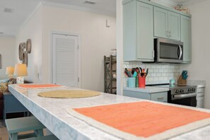 A kitchen with a long countertop, a microwave, and cabinets above. - 🏖️Beachfront with Gulf Views | Multiple Decks | Outdoor Shower | Summer Salt🏖️ (Cape San Blas)