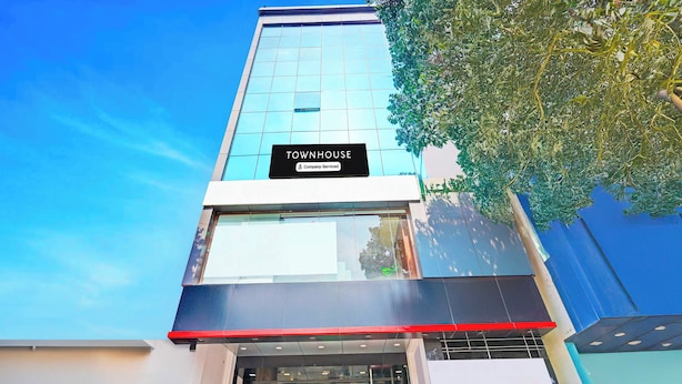Un immeuble moderne avec une enseigne indiquant : « TOWNHOUSE, services d’entreprise ».