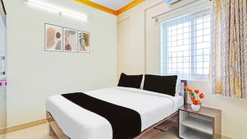 A modern bedroom with a bed, a nightstand, a window with curtains, and wall art.