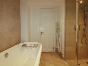 Ein Badezimmer mit einer Badewanne, einer Dusche und einer weißen Tür.
