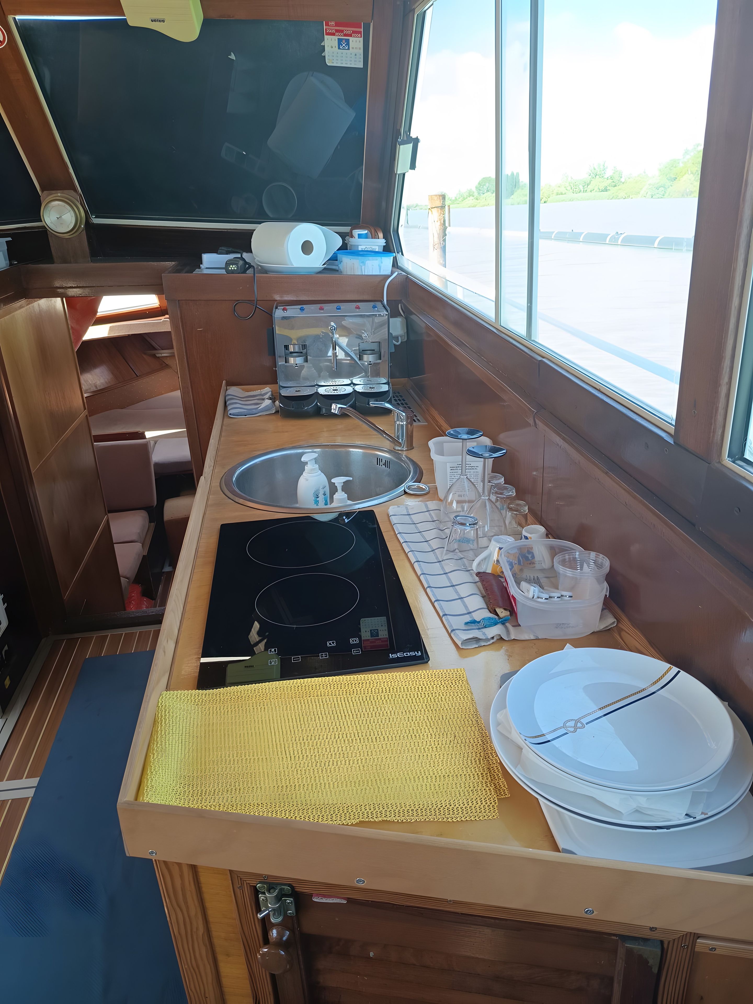 Cocina compacta con un lavamanos, estufa y ventana con vistas al exterior.