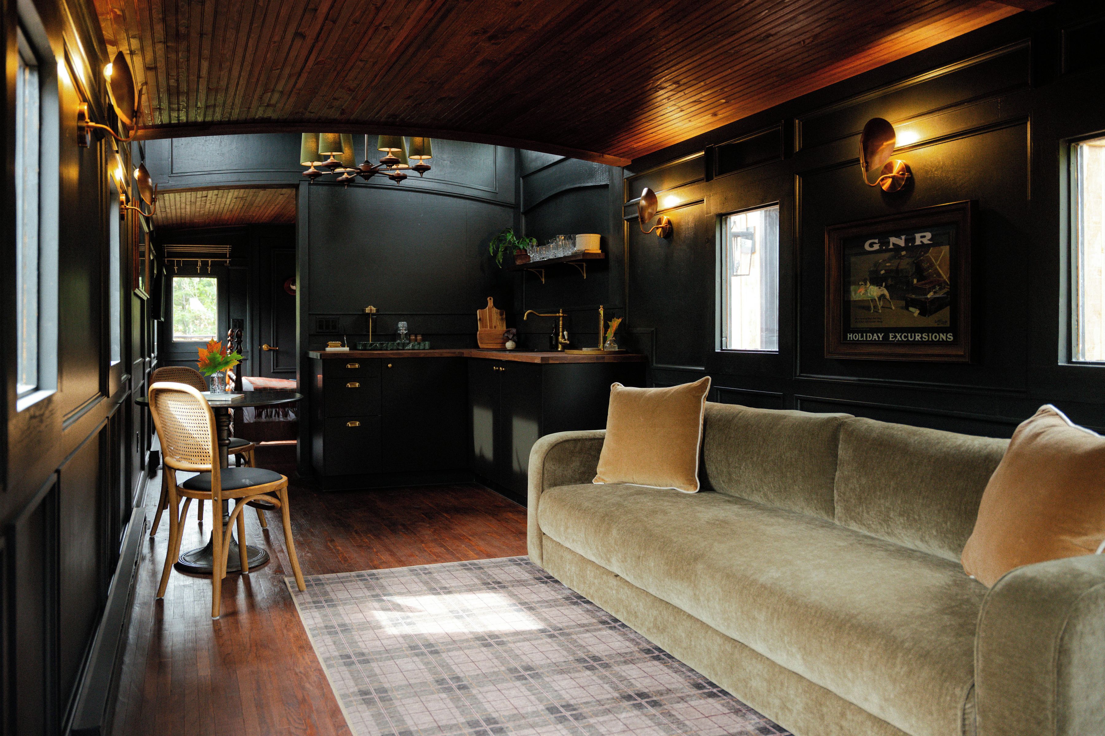 A cozy room with a sofa, a dining table, and a kitchen area.