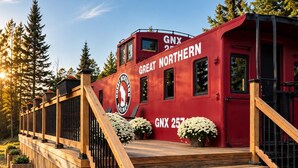 En rød bygning med skilte 'GNX 257' og 'GREAT NORTHERN', en trætrap og et logo med en bjørn.