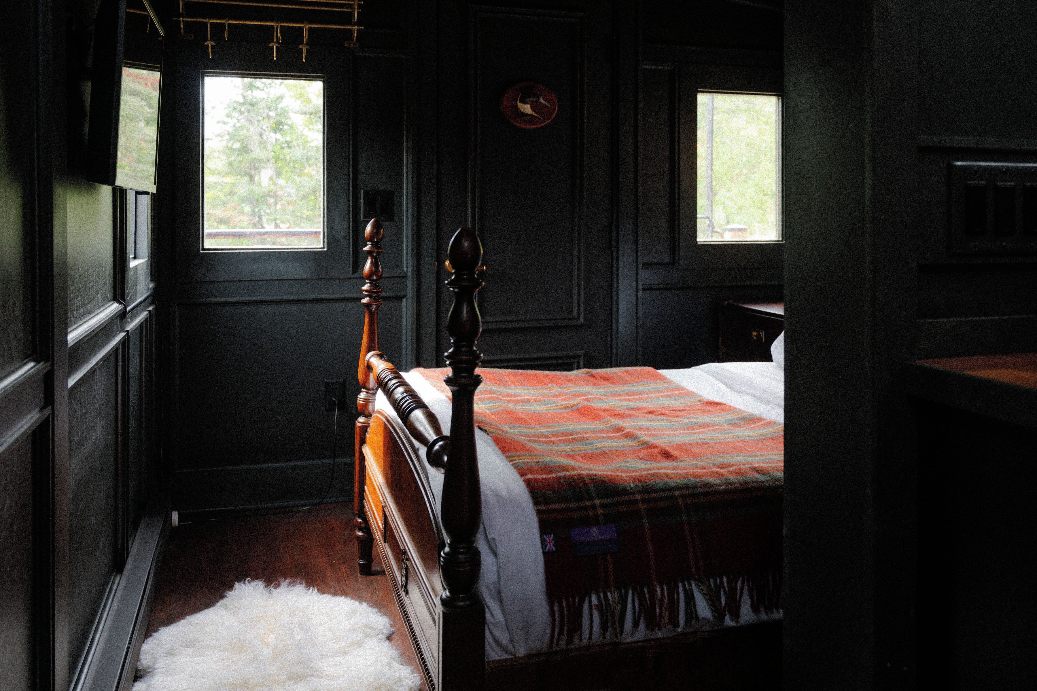 A bedroom with a wooden bed, a window, and a door.