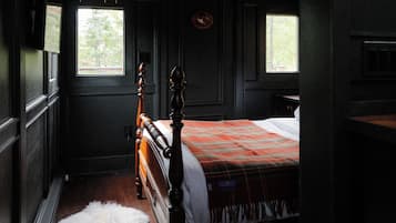 A bedroom with a wooden bed, a window, and a door.