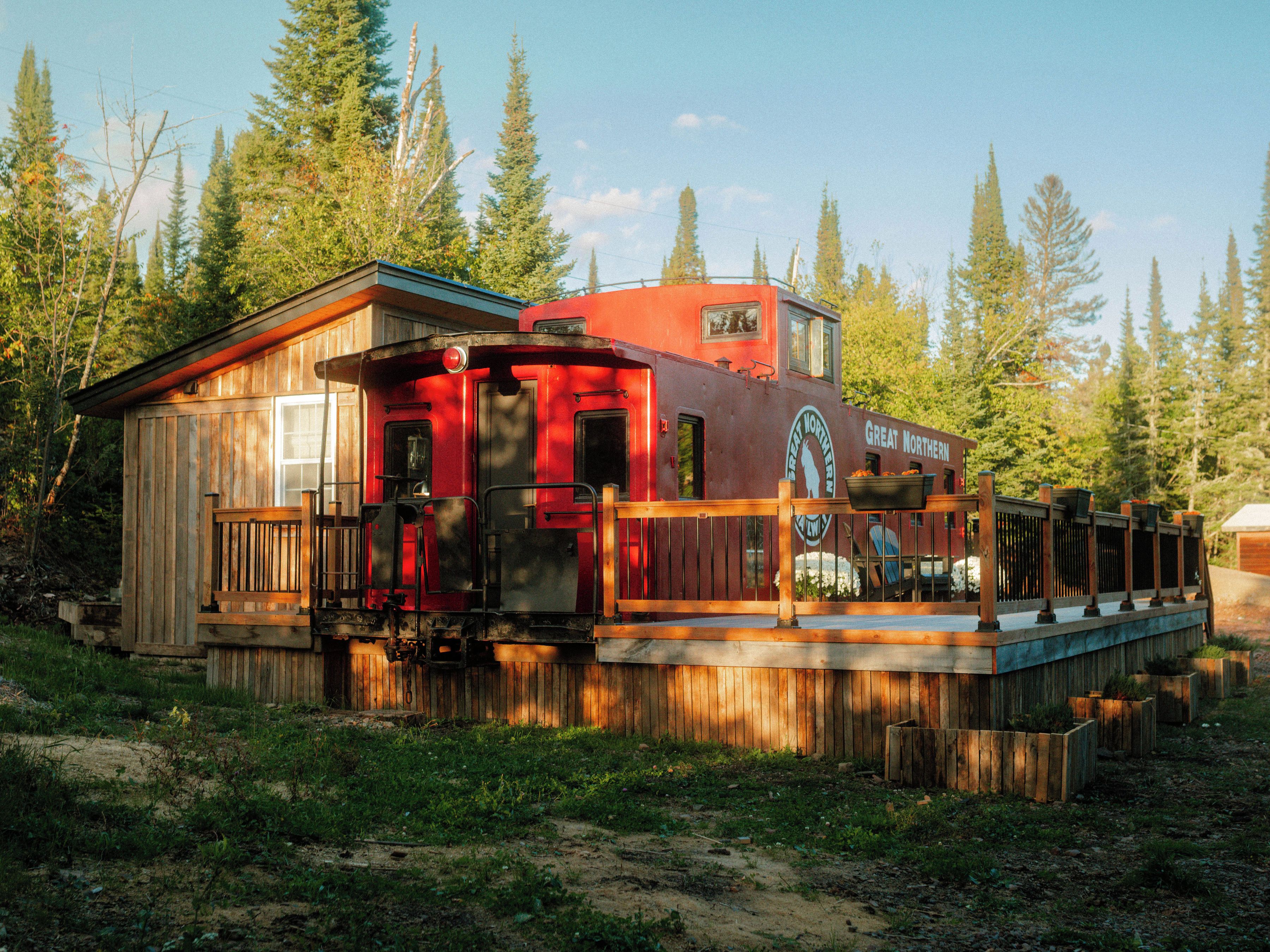 Una cabaña de madera con fachada roja, un balcón y un cartel que dice 'Great Northern'.