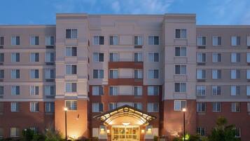 A multi-story hotel with a central entrance, large windows, and a brick facade.