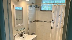 Et badeværelse med toilet, vask og bruser.