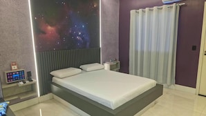 Ein modernes Schlafzimmer mit einem Bett, einem Nachttisch, einer Wand-Klimaanlage und einer Steuerung.
