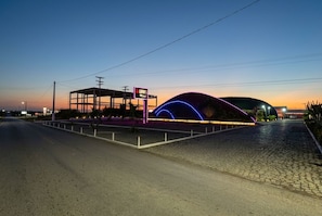 A motel with a distinctive neon sign and a curved entrance.