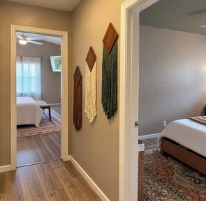 A bedroom with a bed, a nightstand, and a wall-mounted TV.