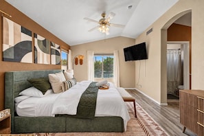 A bedroom with a large bed, a ceiling fan, a TV, and a view of the outdoors. - Pool, Tub & Mini Golf |SF Stadium, Westgate, more (Glendale)