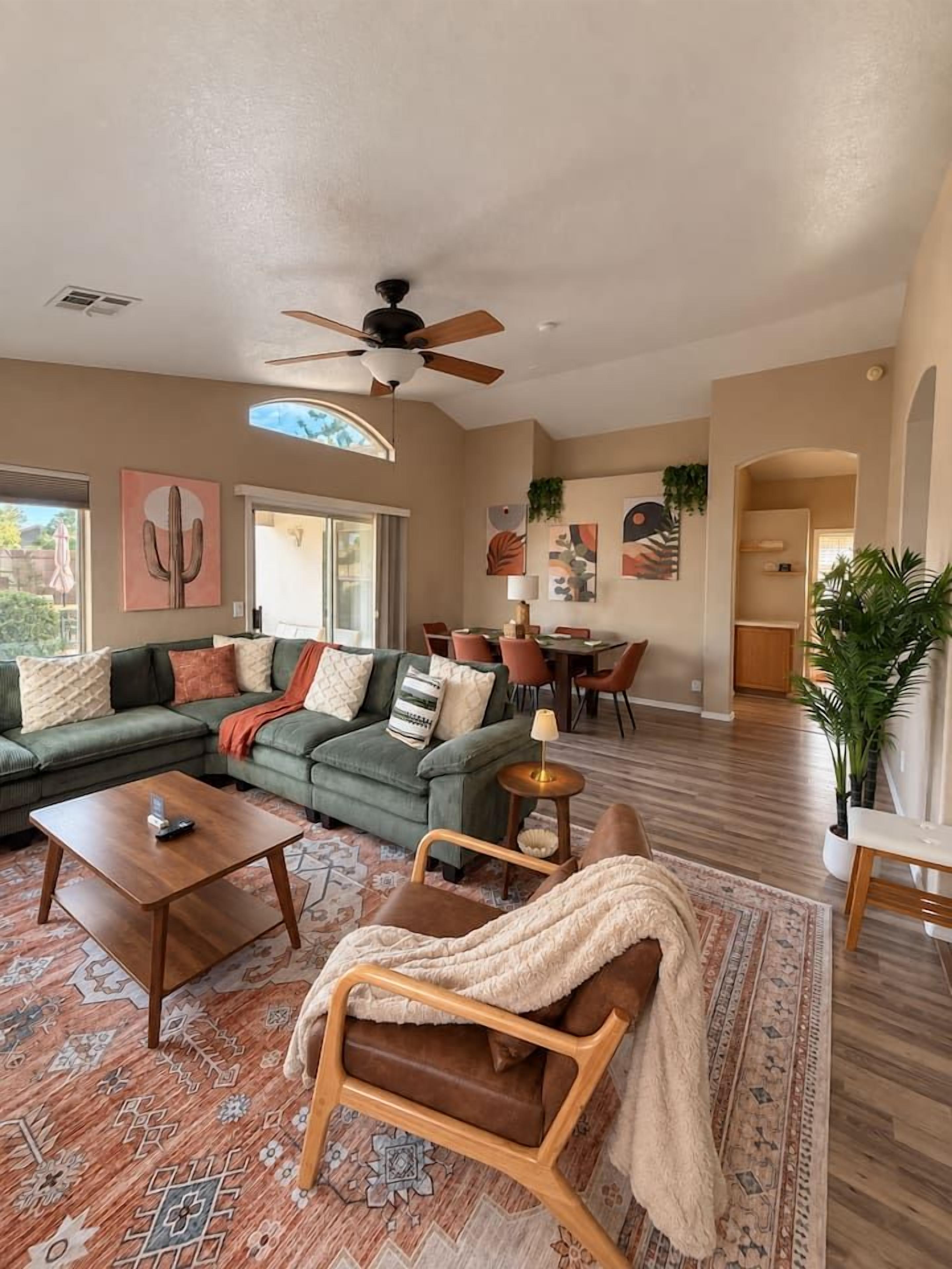A spacious living room with a sectional sofa, a wooden coffee table, and a patterned rug.